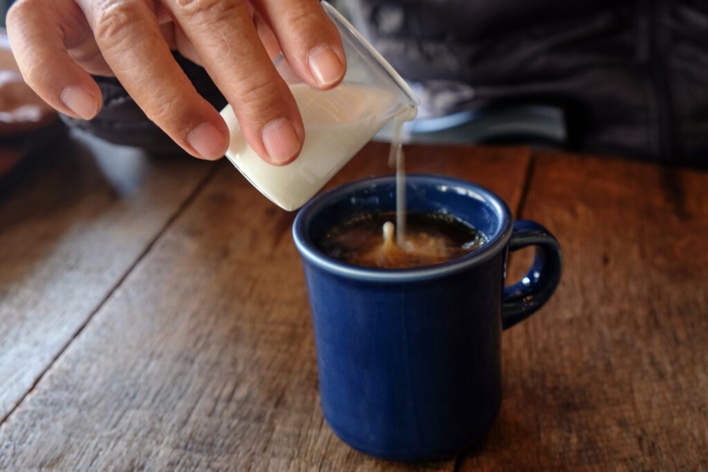 representing non-dairy creamers, someone pouring a creamer into coffee